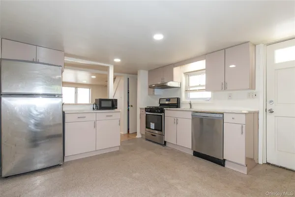 a kitchen with white cabinets and white appliances