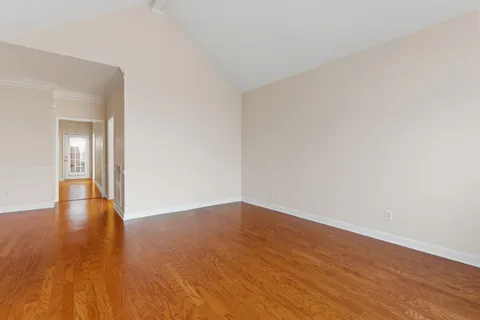 a view of a room with wooden floor and chandelier
