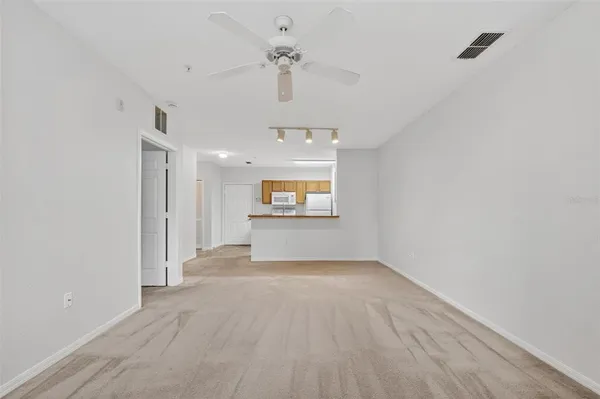 an empty room with a ceiling fan and a window