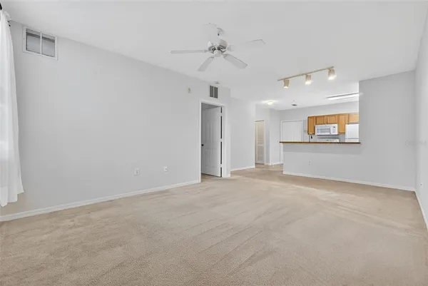an empty room with windows and fan