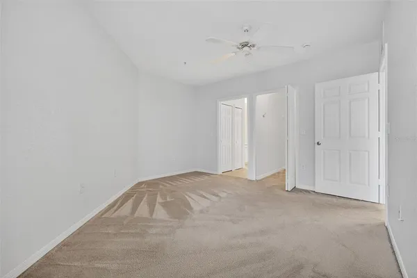 a view of an empty room with a ceiling fan