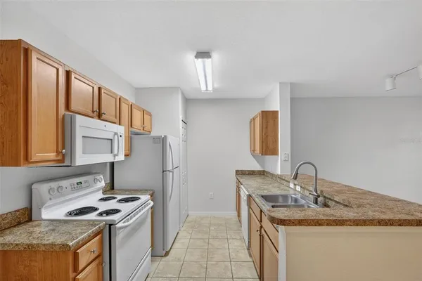 a kitchen with a sink refrigerator and cabinets