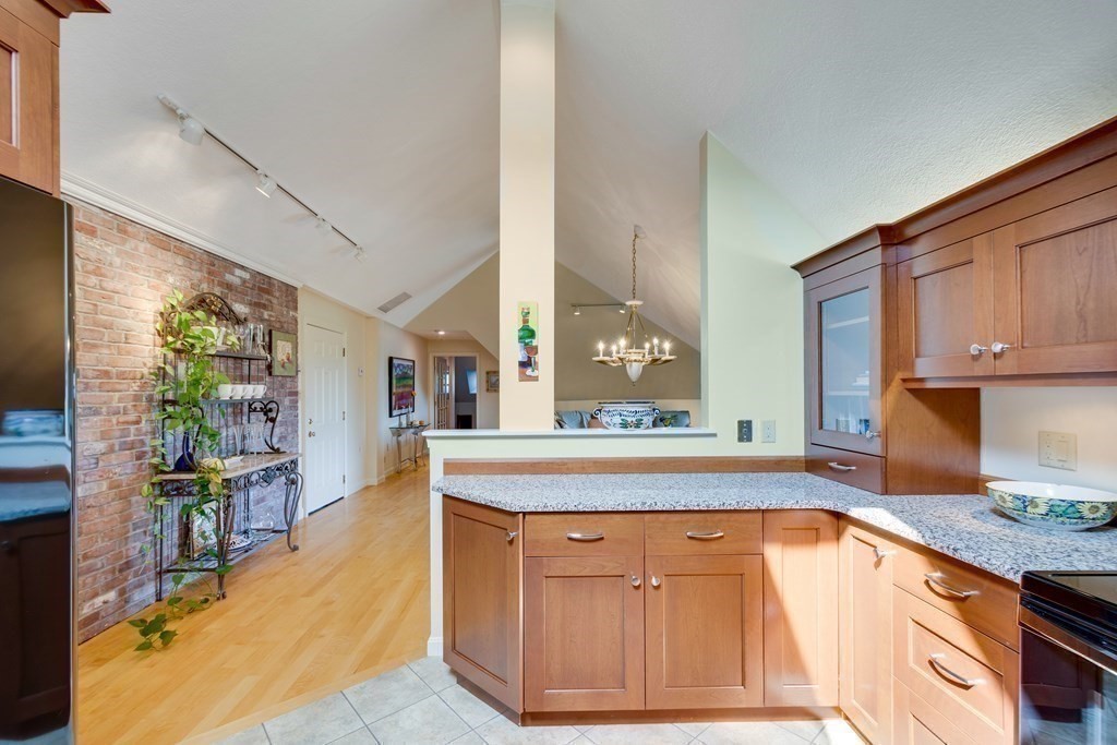 149 Andover Street, Unit 10 Andover, MA 01810 - Photo 11 of 30 a kitchen with stainless steel appliances granite countertop a stove a sink and a wooden cabinets