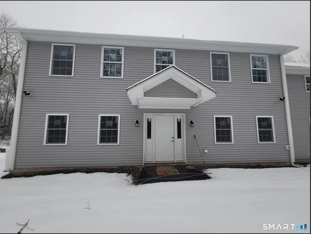 a front view of a house with yard and parking space