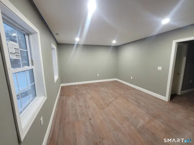 en empty room with wooden floor and entrance