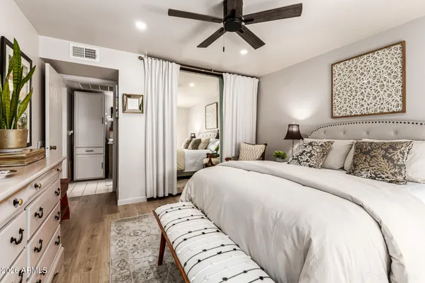 a bedroom with a large bed and a flat tv screen