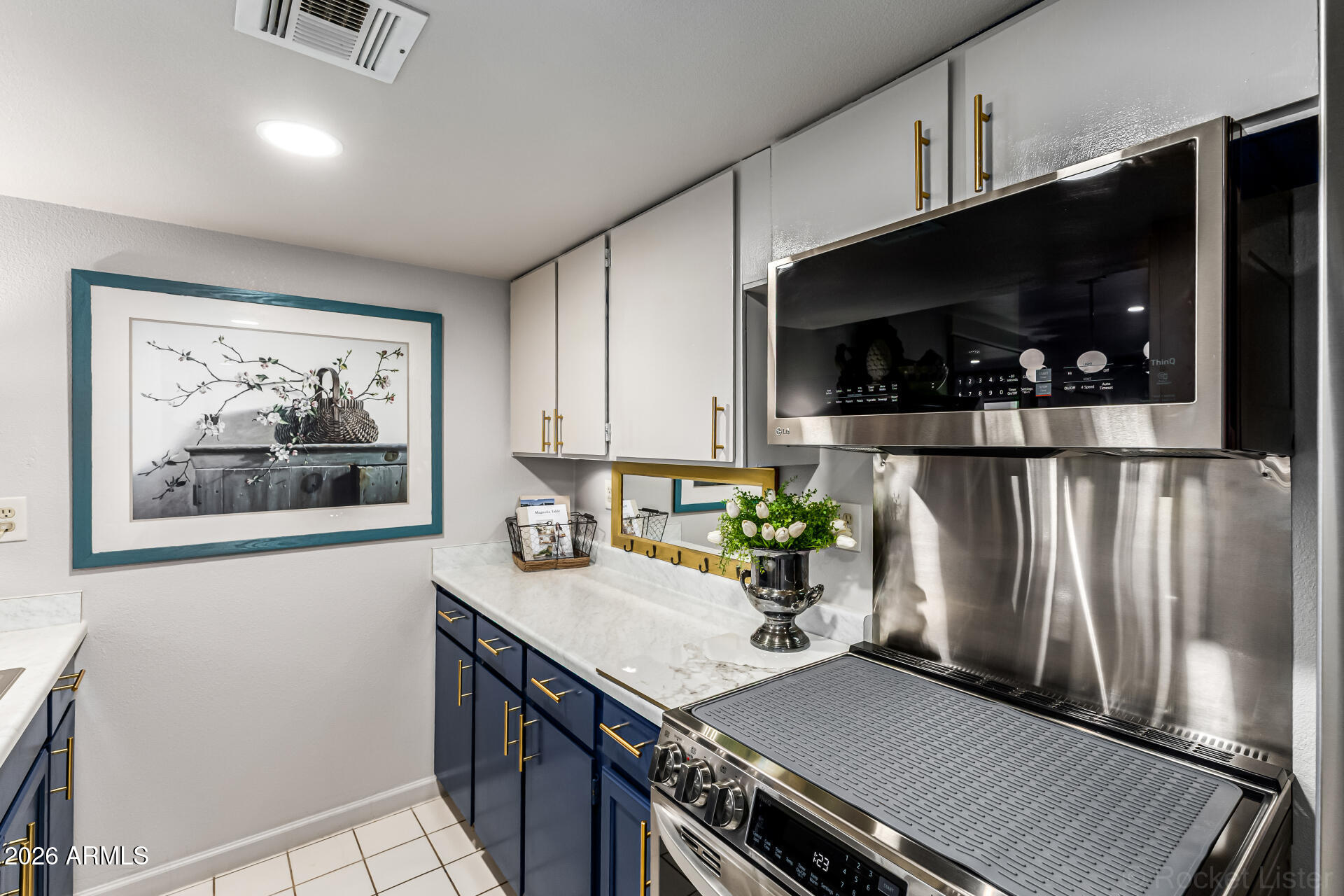 3033 East Devonshire Avenue, Unit 1032 Phoenix, AZ 85016 - Photo 10 of 23 a kitchen with stainless steel appliances a stove refrigerator and microwave