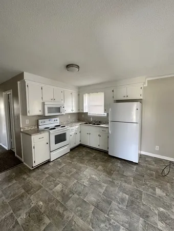 a kitchen with stainless steel appliances a refrigerator sink and cabinets