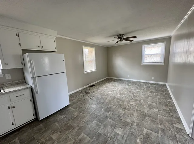 a view of empty room with window and refrigerator