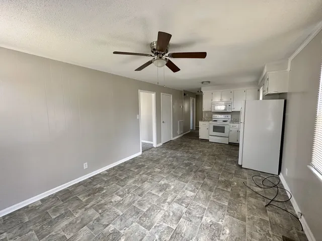 a view of empty room with refrigerator and window