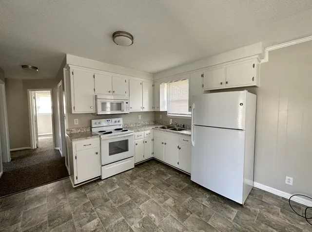 a kitchen with white cabinets and white appliances
