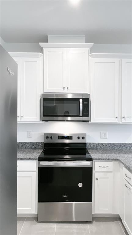 4268 Sadler Road Apopka, FL 32712 - Photo 11 of 28 a kitchen with granite countertop white cabinets and black appliances