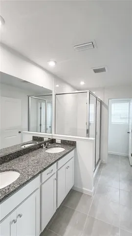 a bathroom with a granite countertop sink and mirror