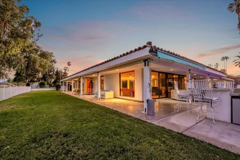 a backyard of a house with table and chairs