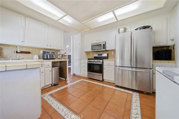 a kitchen with stainless steel appliances granite countertop a refrigerator sink and stove