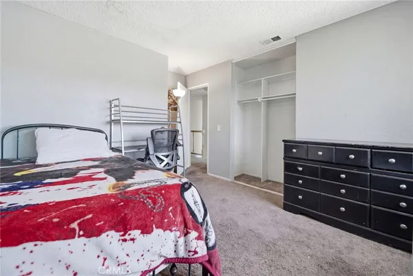 a bedroom with a bed and a dresser in it