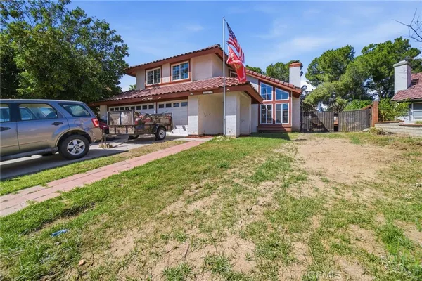 a blue and white house covered with tall trees