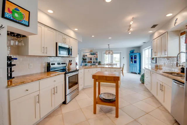 a kitchen with stainless steel appliances kitchen island granite countertop a sink and cabinets