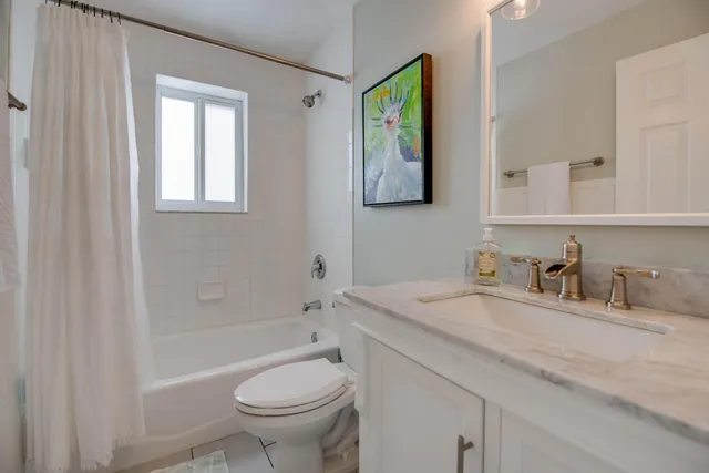 a bathroom with a granite countertop toilet a sink and a mirror