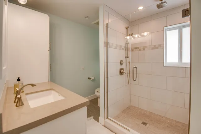 a bathroom with a shower sink and mirror