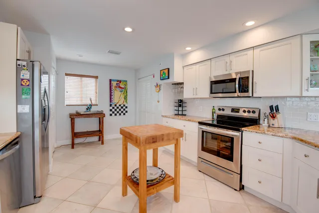 a kitchen with stainless steel appliances granite countertop a stove a sink and a refrigerator