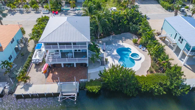 an aerial view of a house with outdoor space and a swimming pool