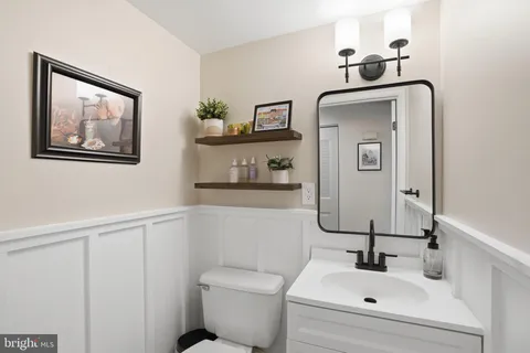 a bathroom with a toilet sink and mirror