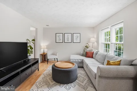 a living room with furniture a flat screen tv and a window