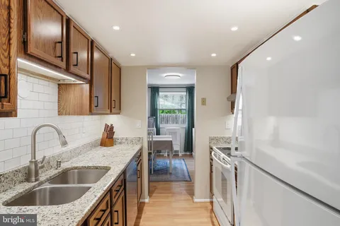 a kitchen with granite countertop a sink stainless steel appliances and cabinets