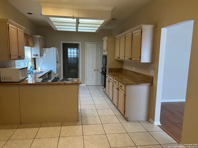 a kitchen with stainless steel appliances granite countertop a refrigerator and a stove