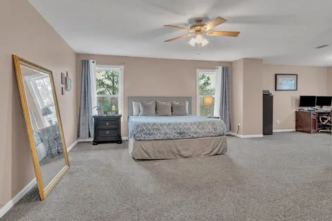 a spacious bedroom with a bed and a chandelier