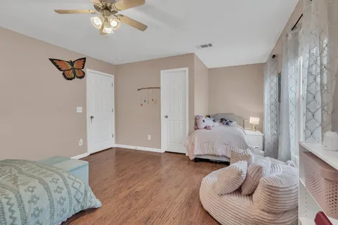 a bedroom with a bed and wooden floor