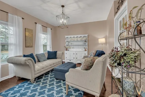 a living room with furniture and a chandelier