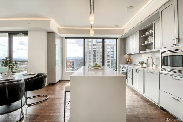 a large kitchen with kitchen island a large window cabinets a sink and stainless steel appliances