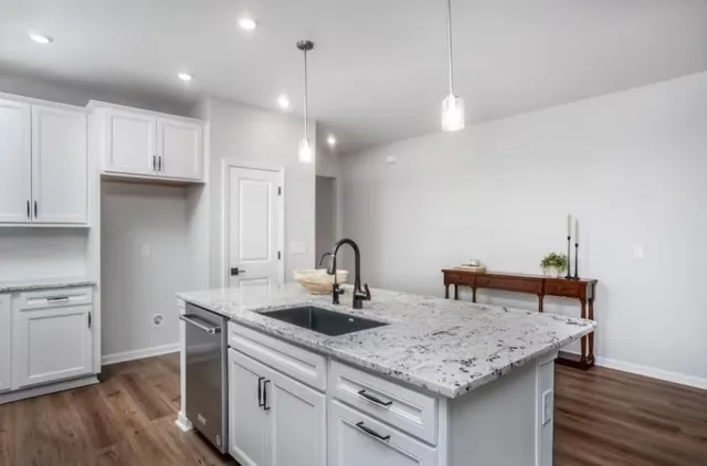 a kitchen with a sink cabinets and wooden floor