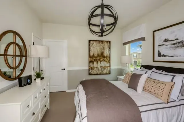 a bedroom with a bed and a chandelier