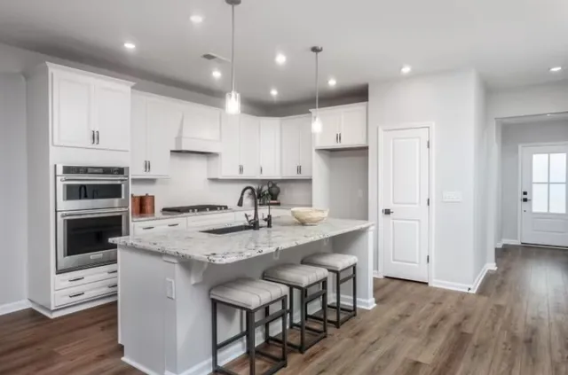 a kitchen with stainless steel appliances granite countertop a stove a sink a refrigerator and a microwave