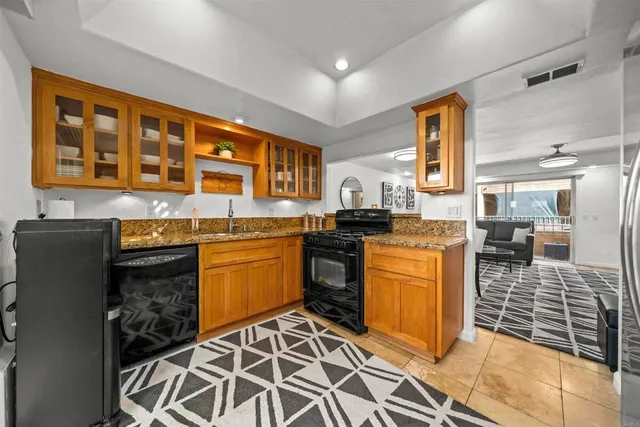 a living room with furniture a flat screen tv and a refrigerator