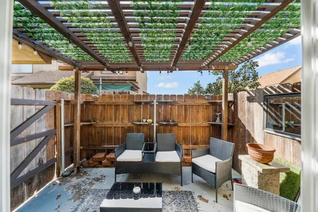 a view of a white house with a large tree and flower plants