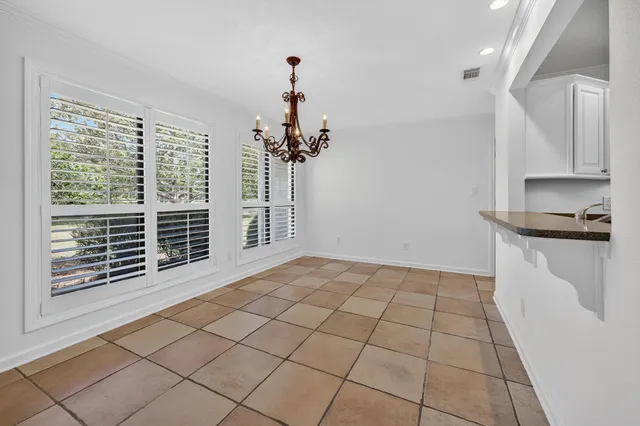 a kitchen with granite countertop white cabinets stainless steel appliances a sink and a window