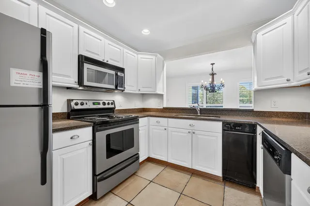 a bathroom with a granite countertop sink a toilet a mirror and shower