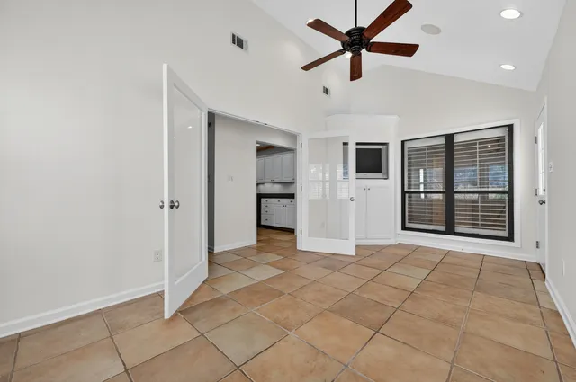 a view of empty room with window and ceiling fan