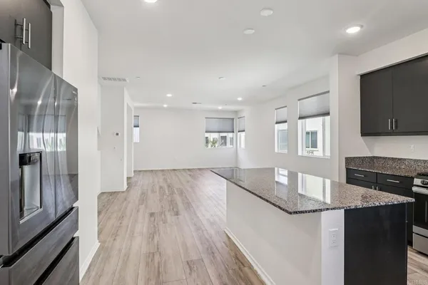 a view of kitchen island wooden floor center island and stainless steel appliances