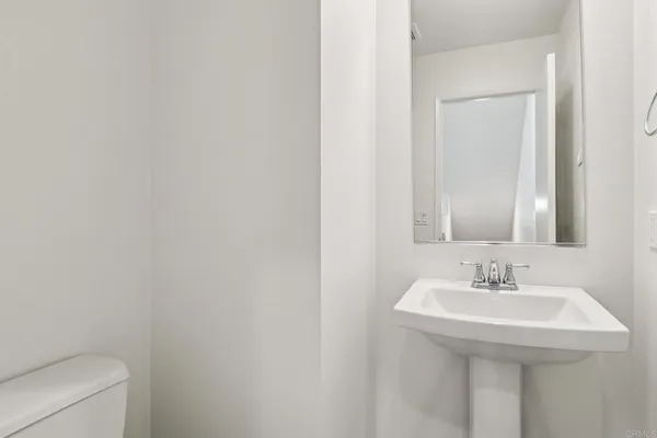 a bathroom with a sink a toilet and a mirror