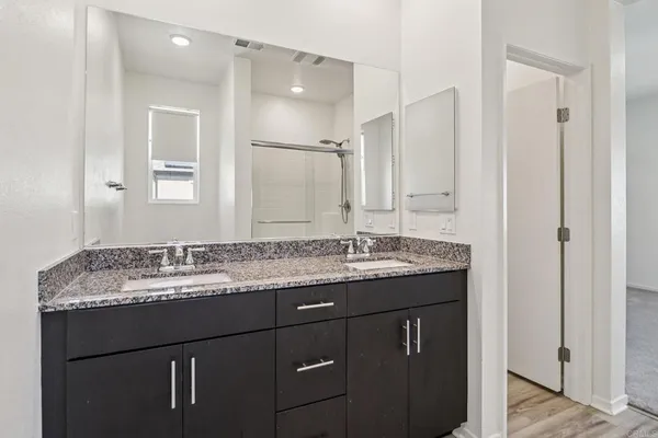 a bathroom with a granite countertop sink and a mirror