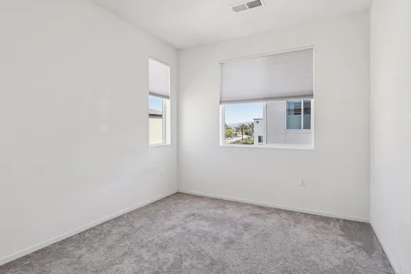 an empty room with windows and closet