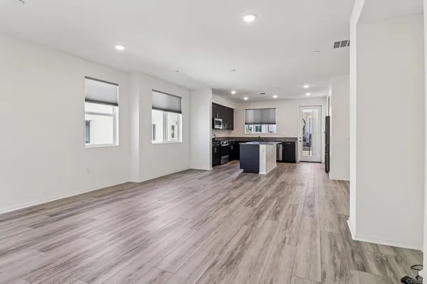 a view of a kitchen with a refrigerator and wooden floor