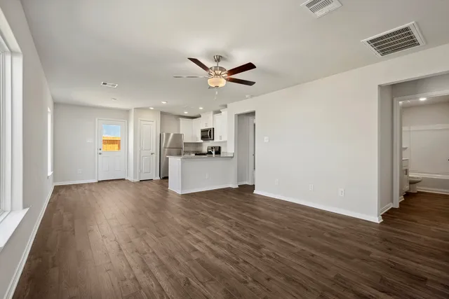 a view of a kitchen with a sink a ceiling fan and wooden floor