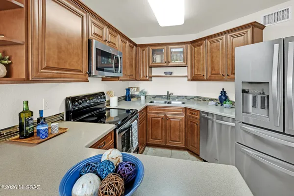 a kitchen with stainless steel appliances a stove a sink and a refrigerator