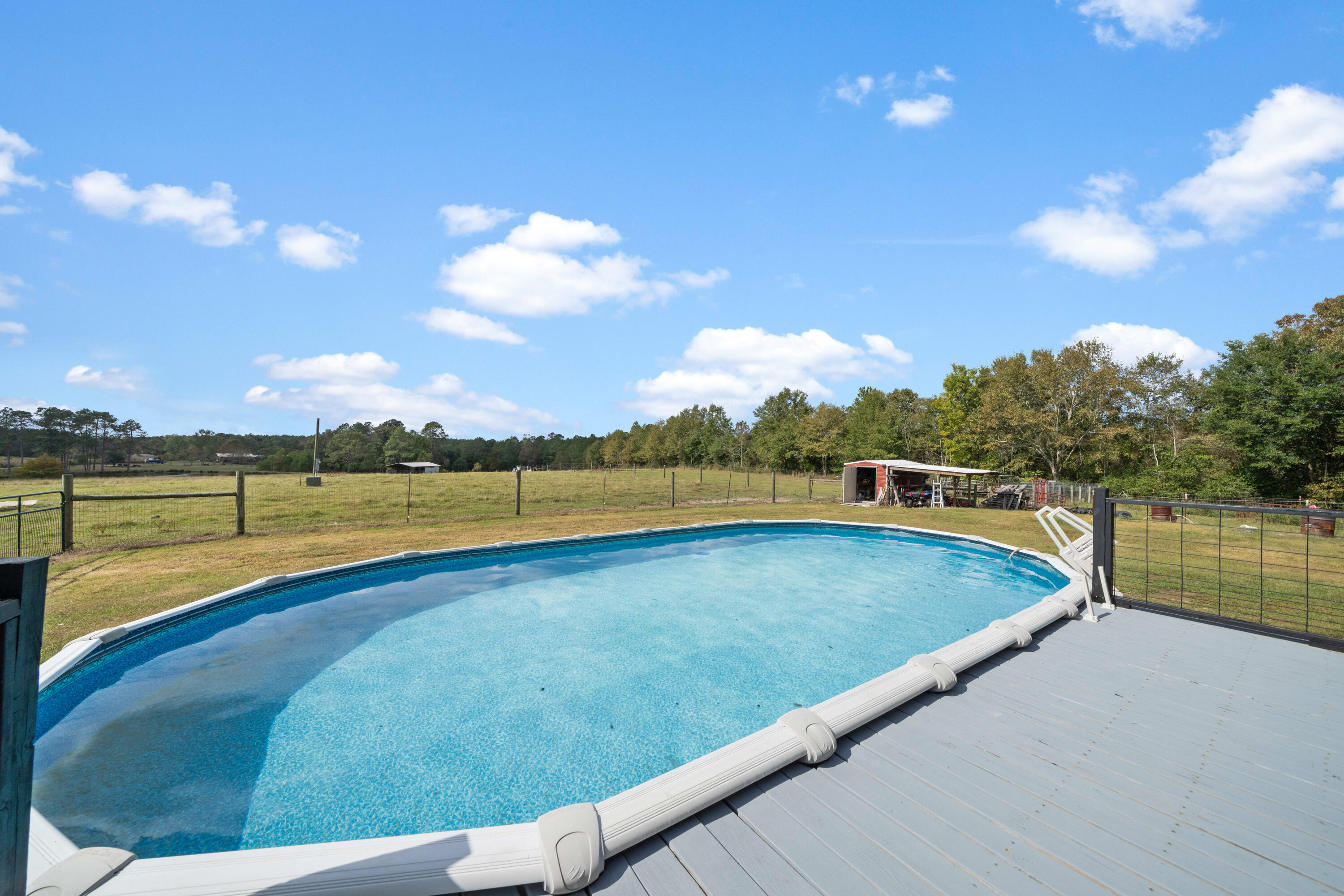 8320 Thames Road Baker, FL 32531 - Photo 41 of 48 a view of a swimming pool and lake from a seating space